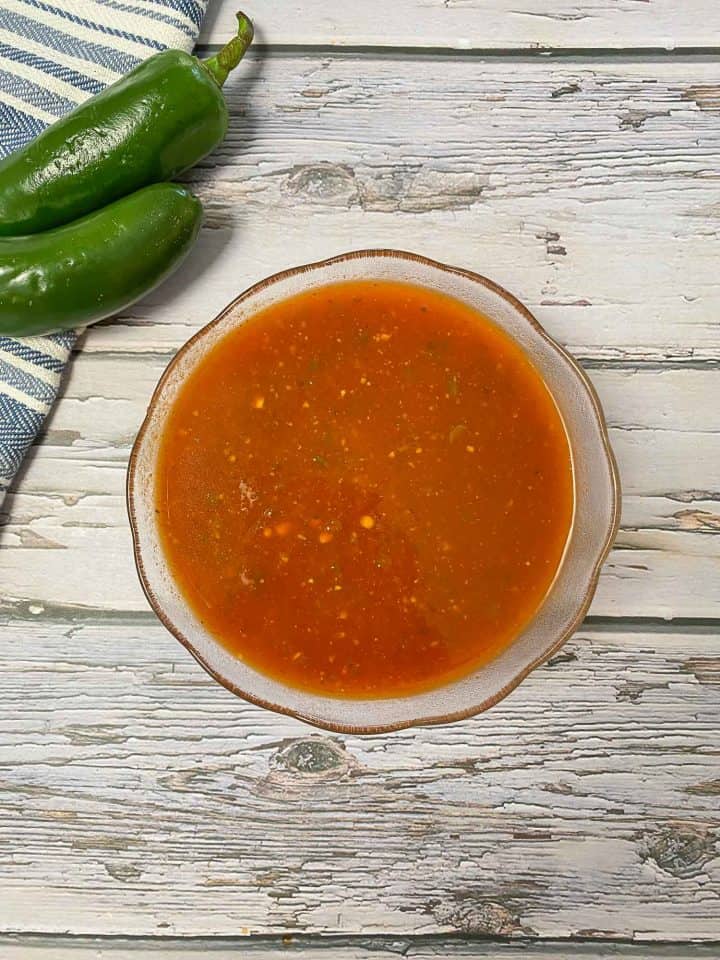 red sauce in glass bowl on grey deck
