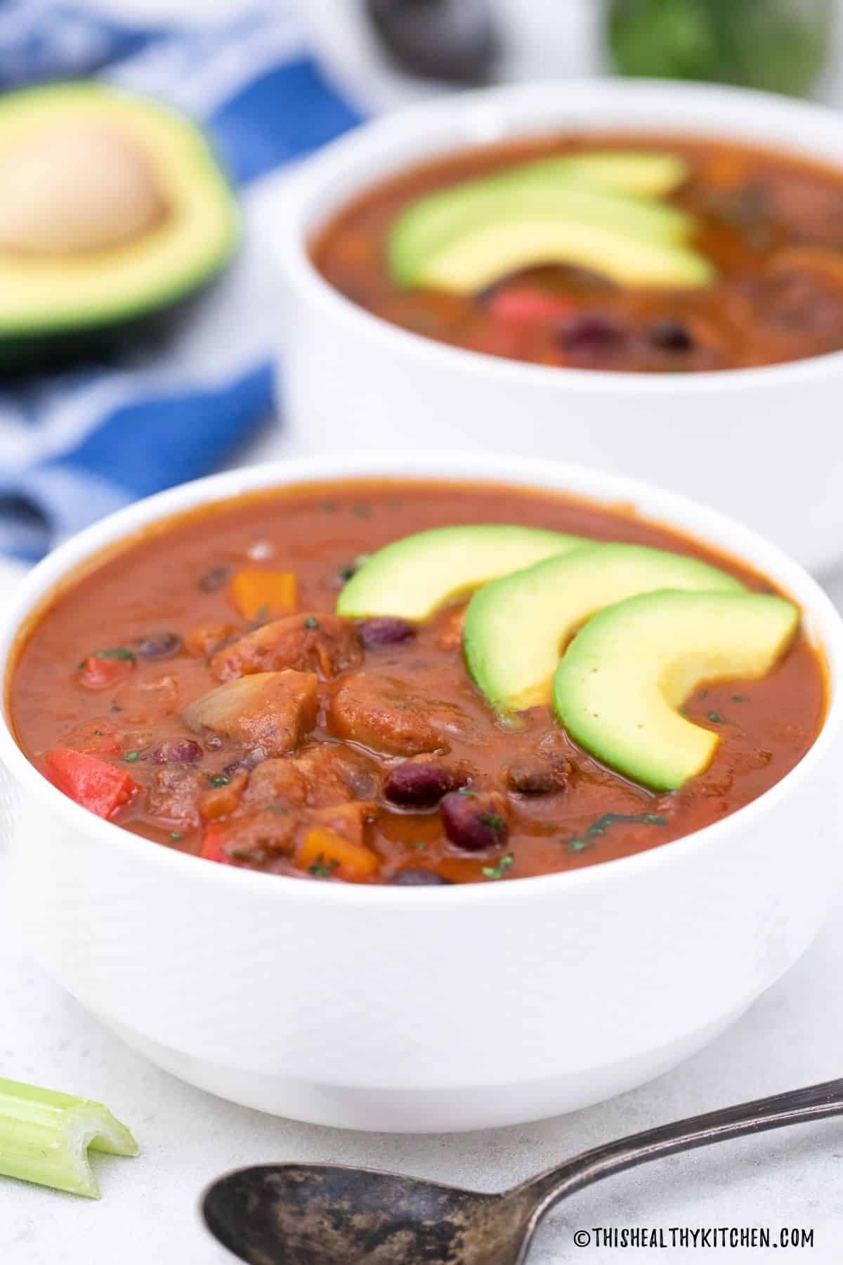 Two bowls filled with Instant Pot bean soup with avocado garnish.