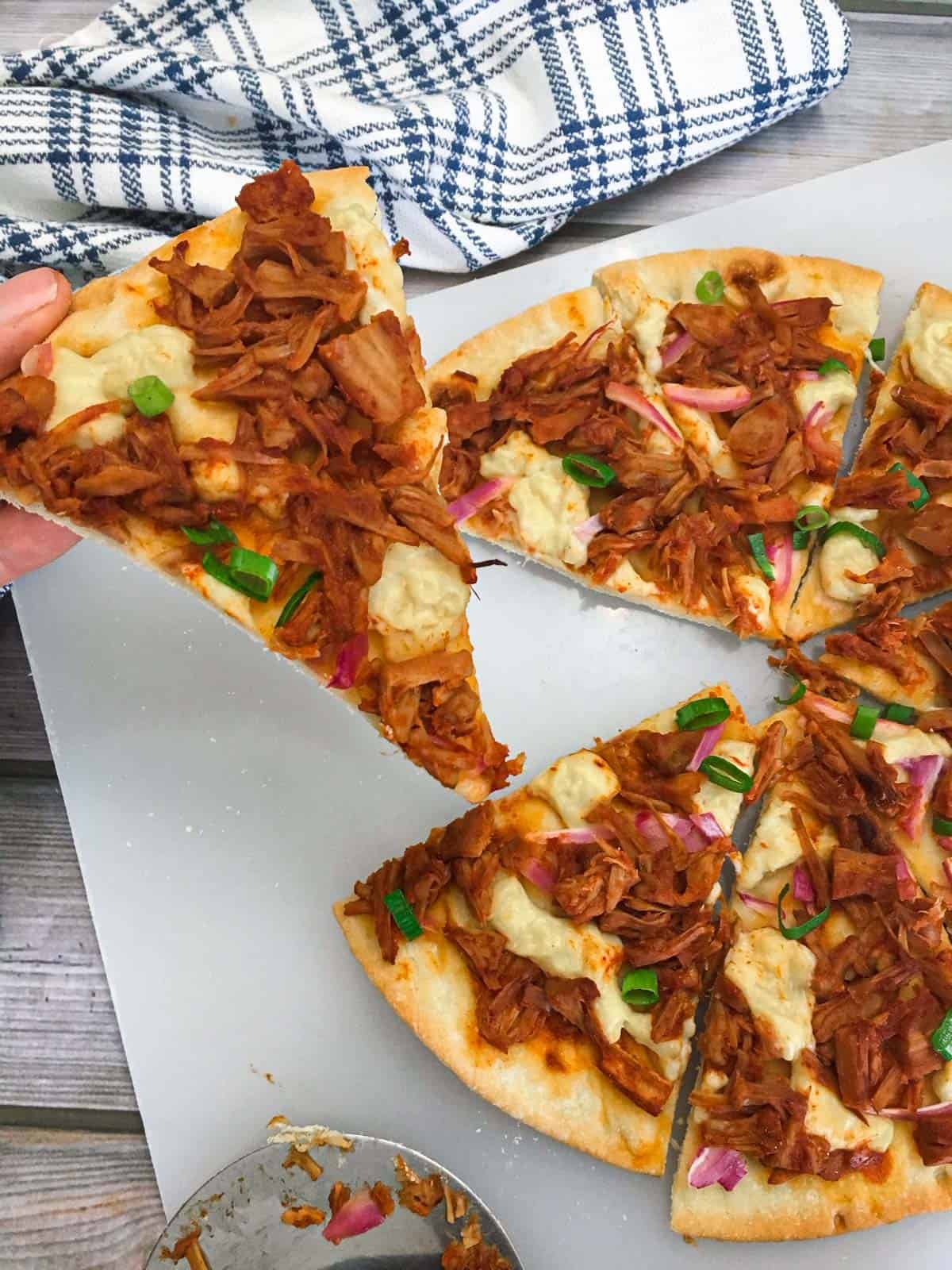 hand lifting slice of pizza