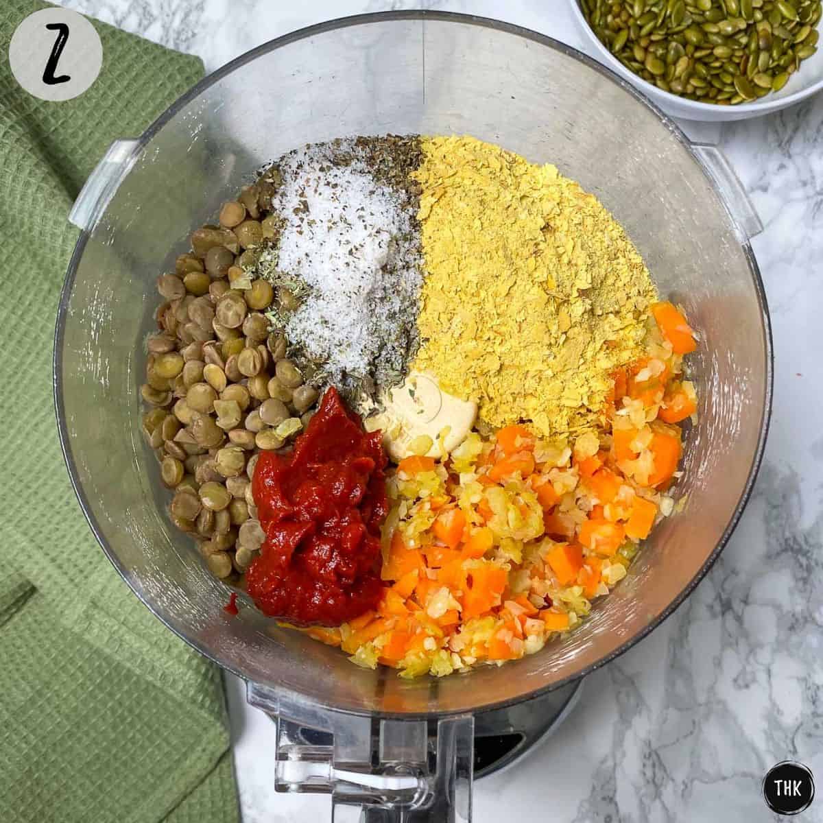 Food processor with lentils, veggies, tomato paste and seasoning.