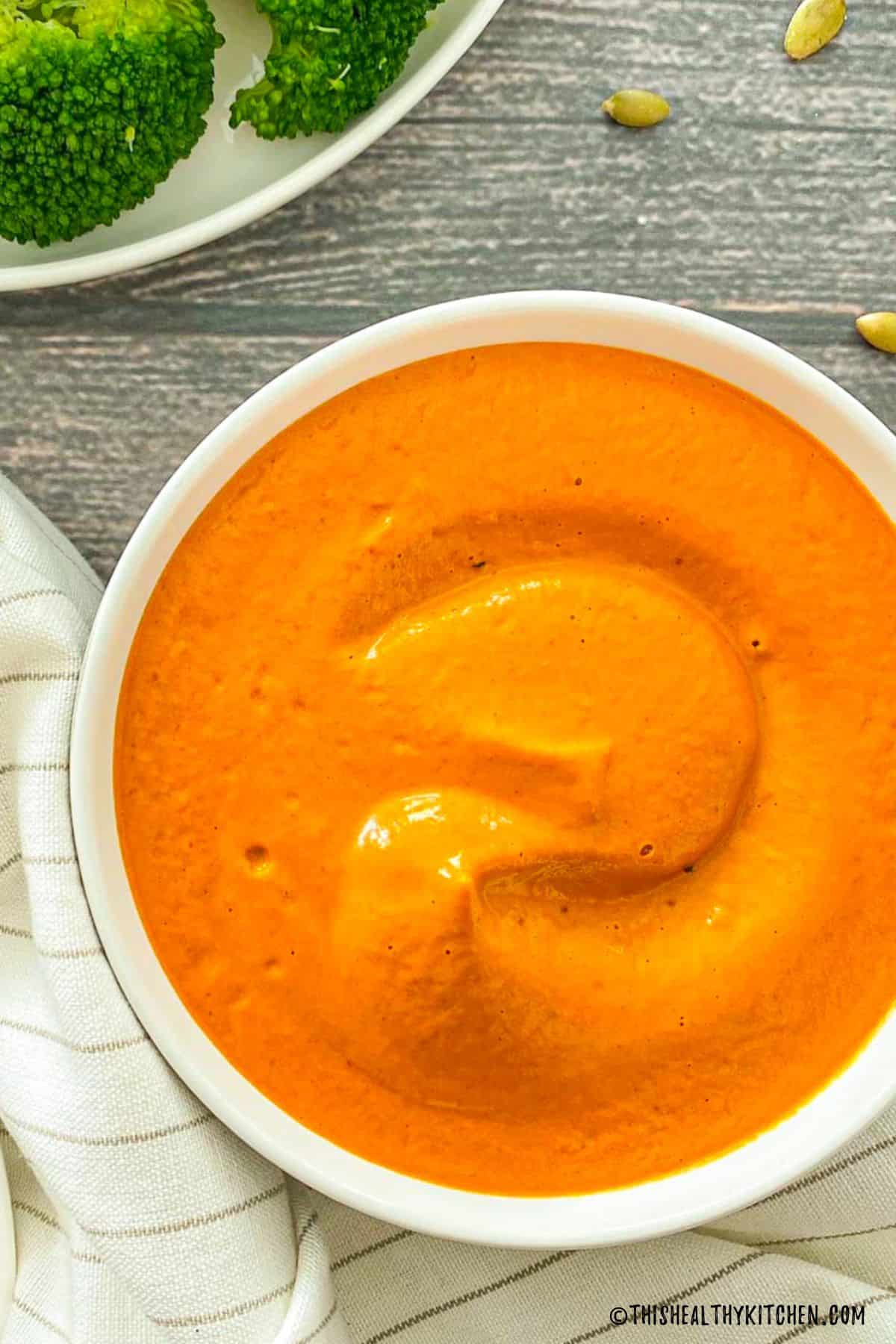 Bowl of orange nacho cheese sauce.