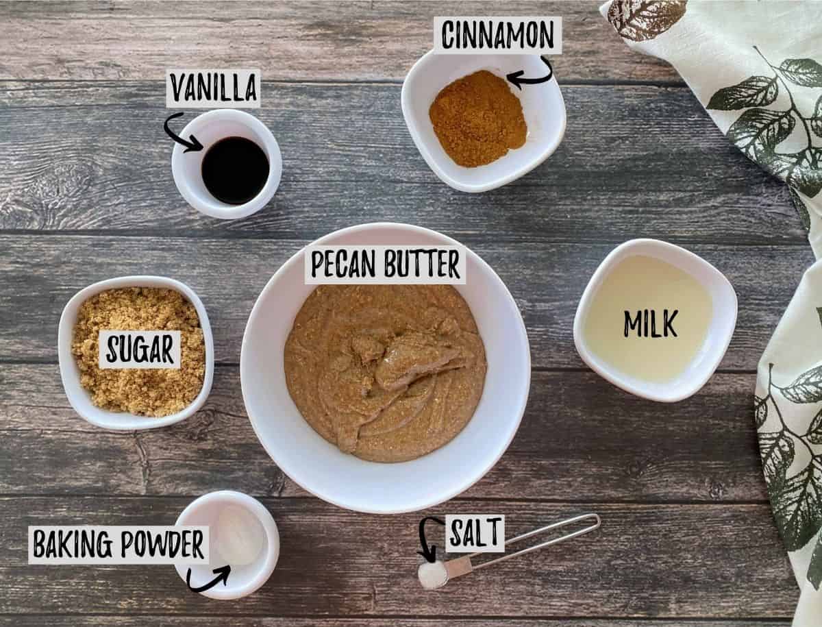 Ingredients to make pecan butter cookies scattered on brown deck.