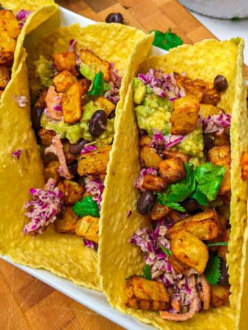 Corn tortillas stuffed with potatoes, black beans and coleslaw.