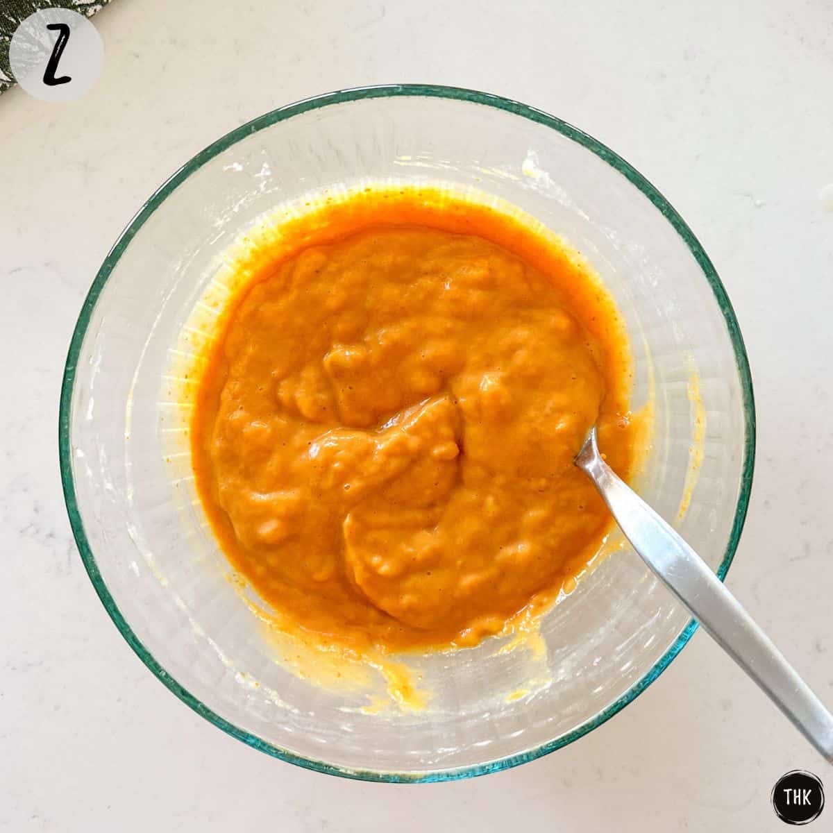 Orange batter inside mixing bowl.
