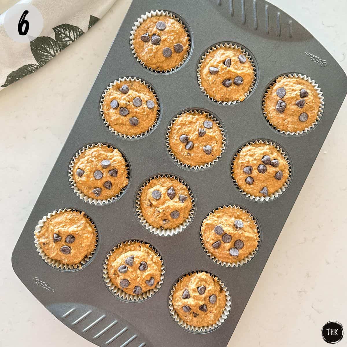 Raw banana pumpkin muffin batter in muffin tin before baking.