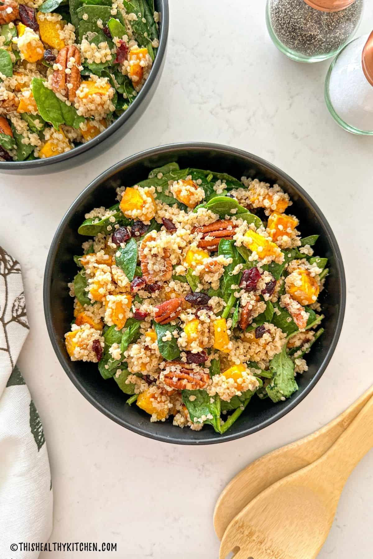 Pumpkin quinoa salad inside black serving dish.