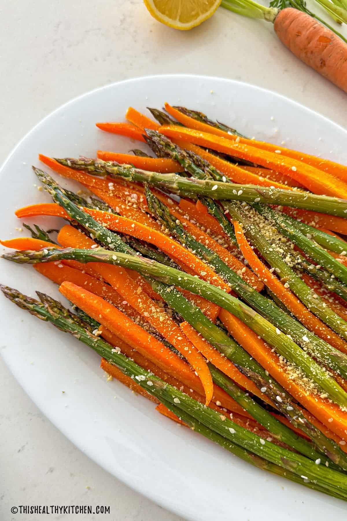 Platter with roasted asparagus and carrots on top.