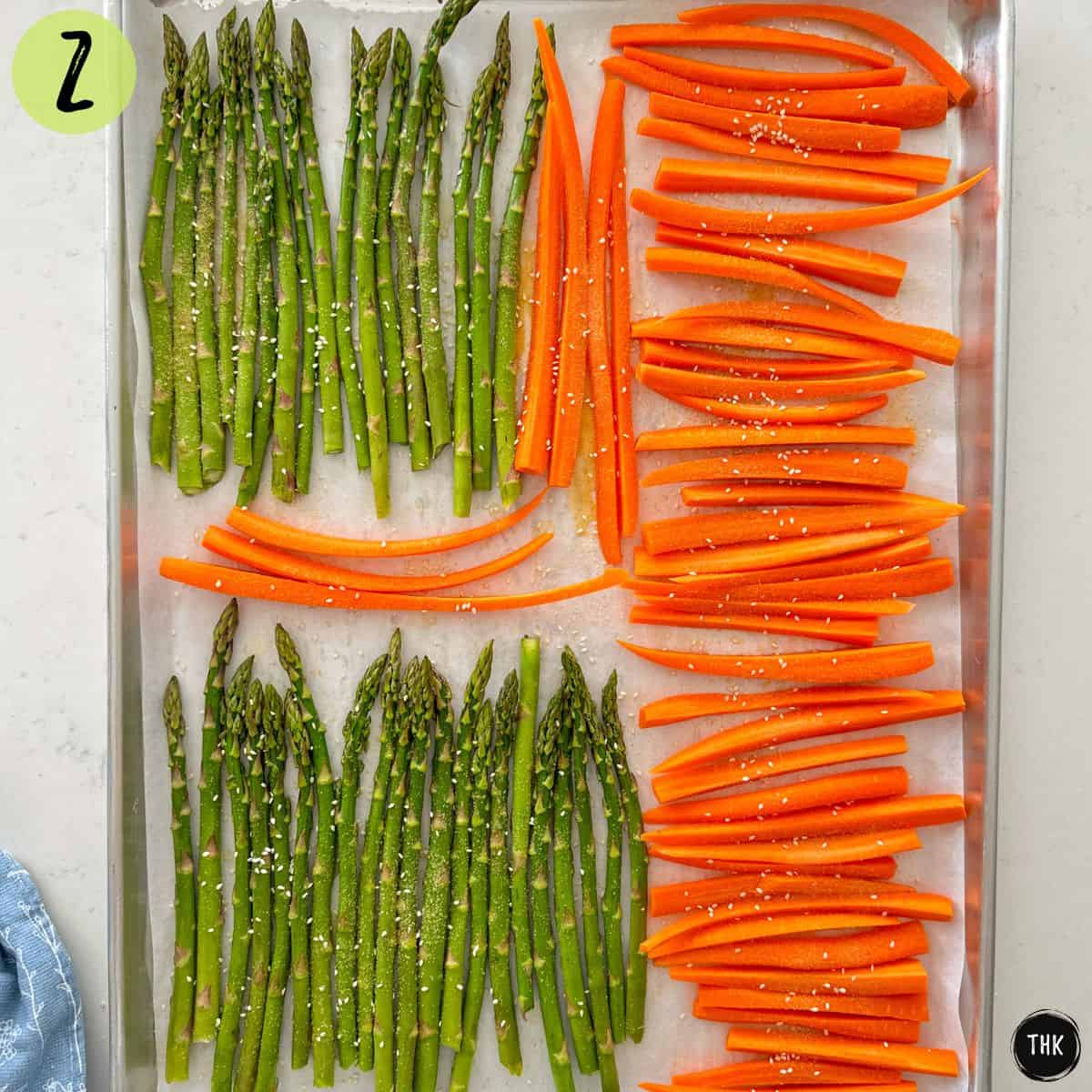 Roasted asparagus and carrots in a single layer on baking pan.