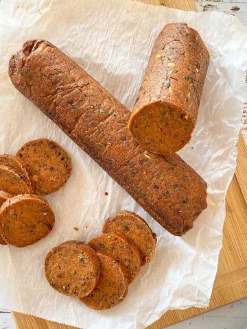 vegan salami on cutting board with slices cut.