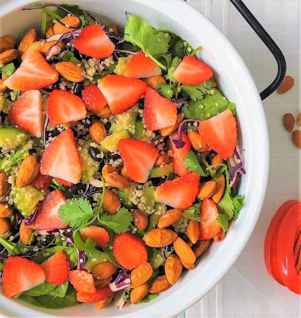 Strawberry Spinach Salad in serving bowl with scattered almonds
