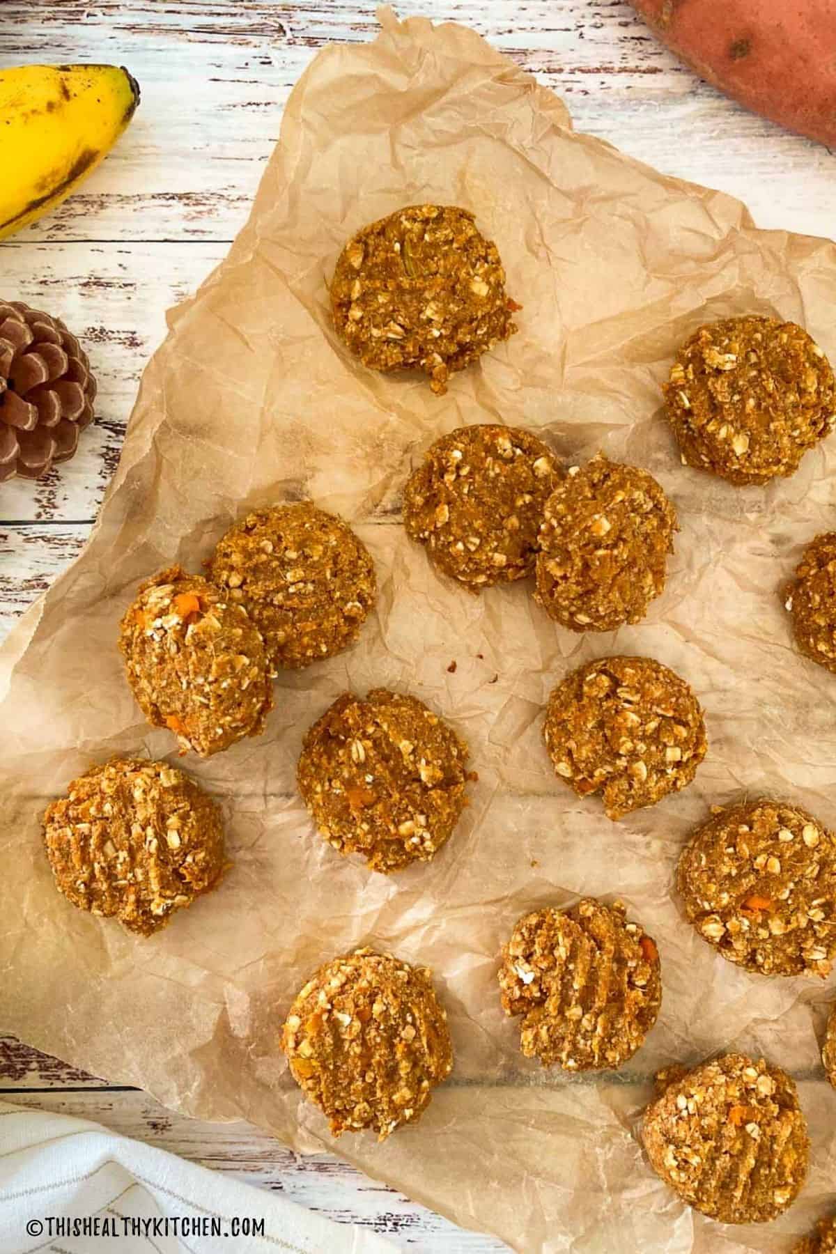 Oatmeal cookies with sweet potato on sheet of parchment paper.