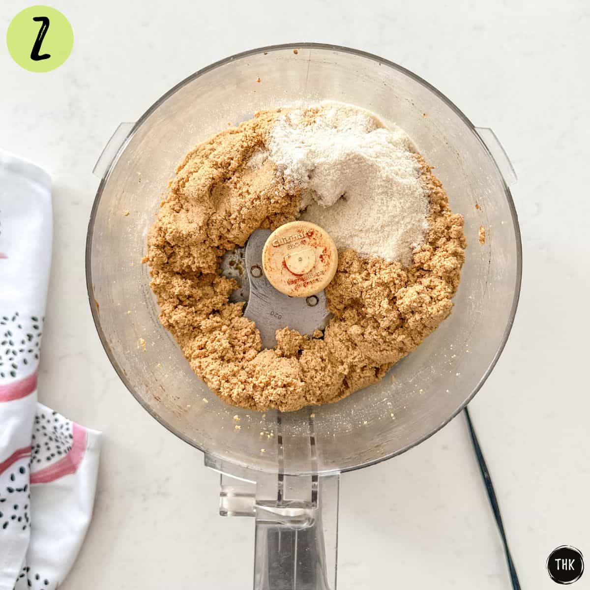 Blended tofu in food processor bowl with brown rice flour on top.