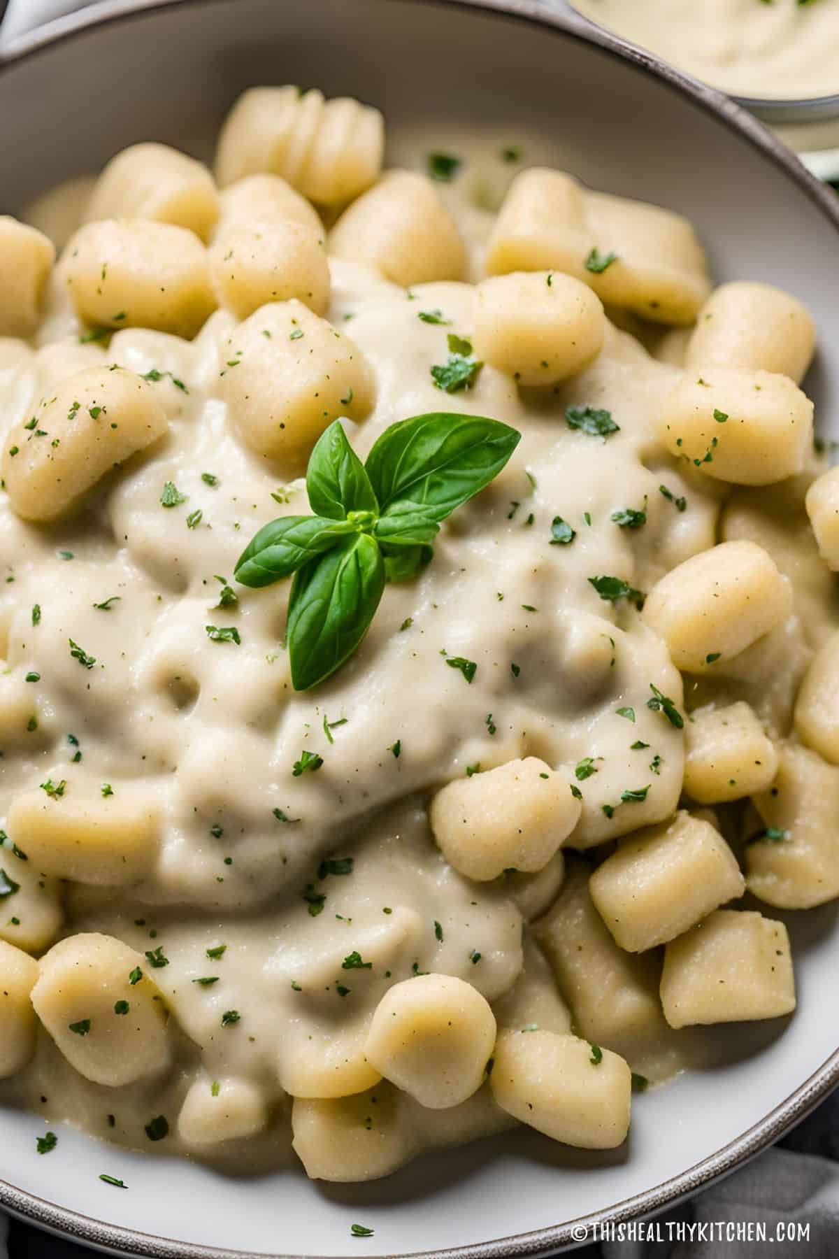 Gnocchi with vegan alfredo sauce and fresh basil on top.