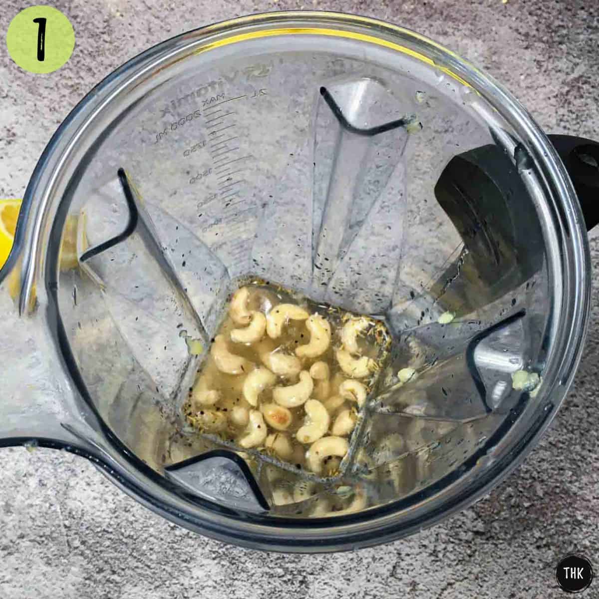 Blender with cashews, spices and water inside.