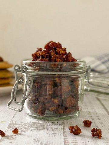 vegan bacon bits in glass jar with pancakes in the background.