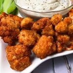 Tray of buffalo cauliflower bites with bowl of ranch dip in the middle.