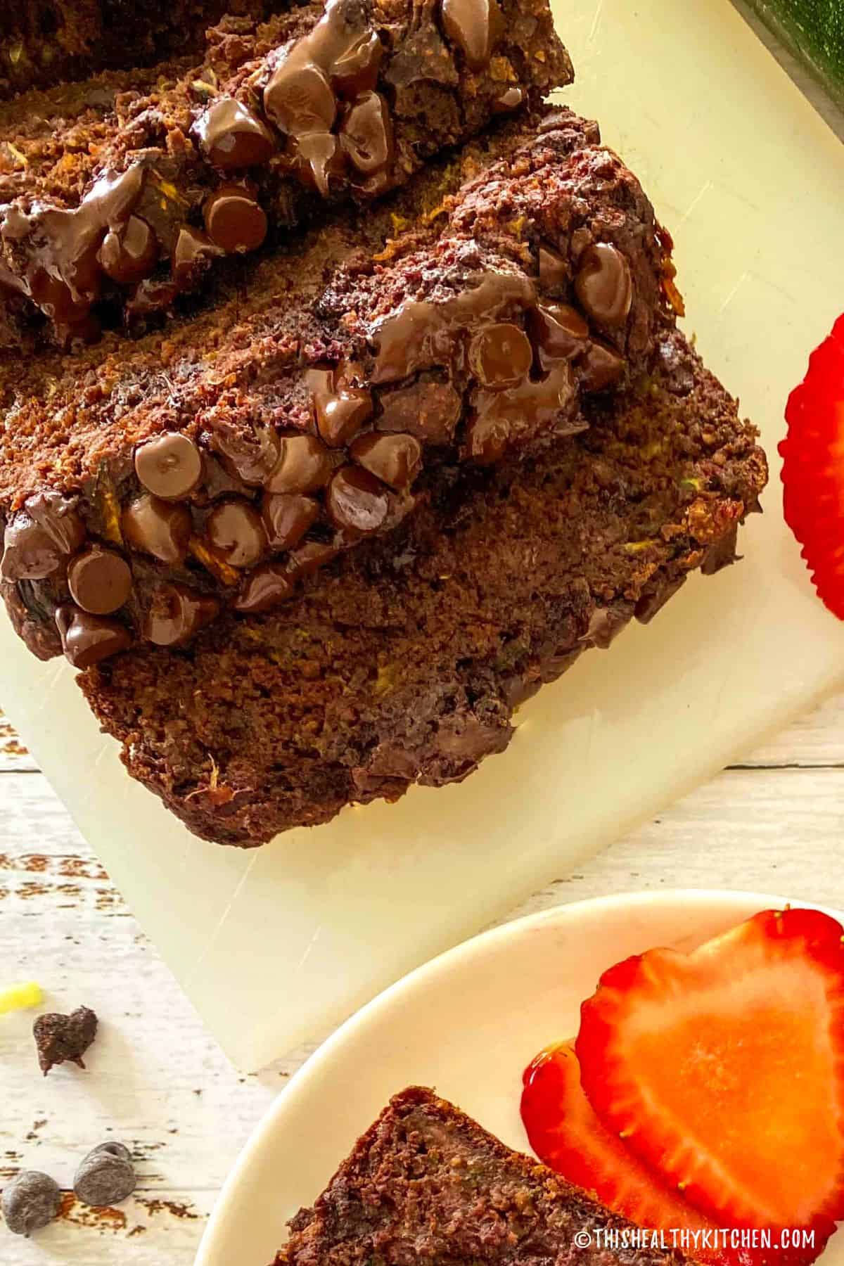 Sliced chocolate zucchini bread on cutting board.