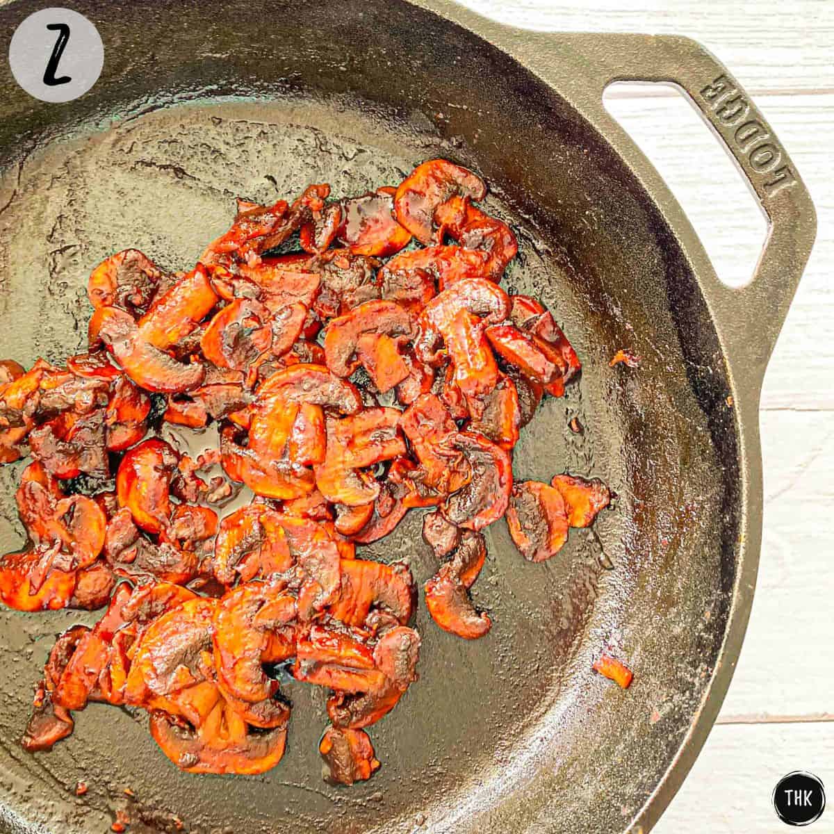 Sautéed mushrooms inside a cast iron pan.