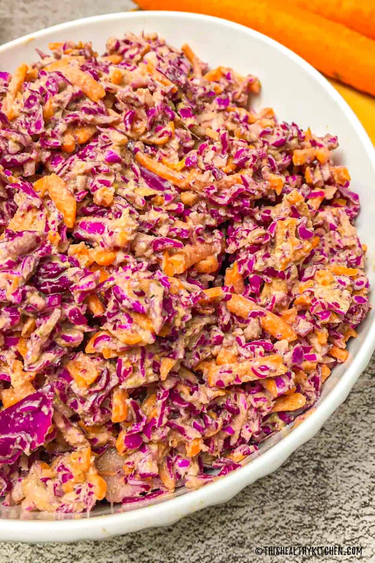 White bowl with coleslaw inside.