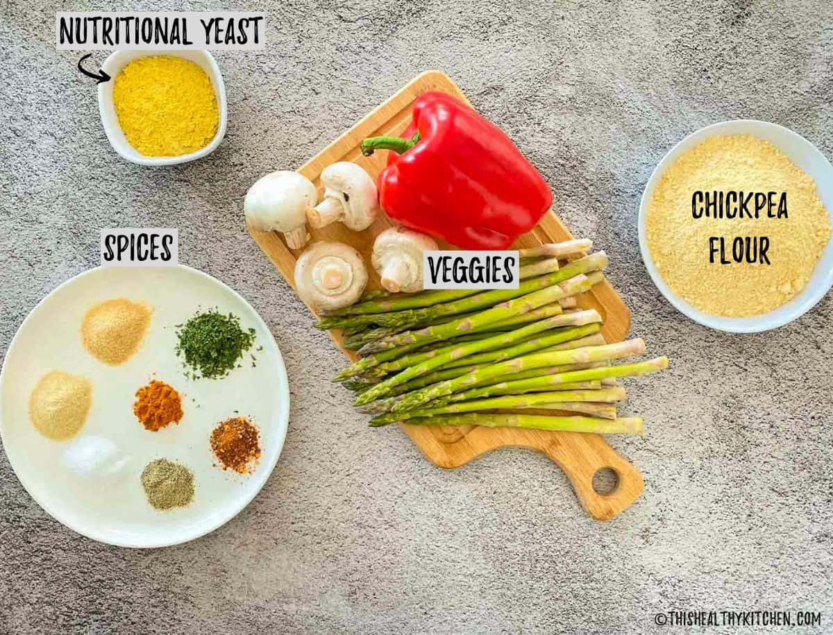 Bowl of chickpea flour, cutting board with veggies, and plate of spices.