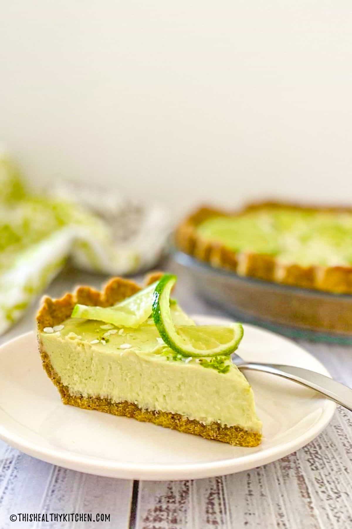 Side view of a slice of key lime pie on a plate.