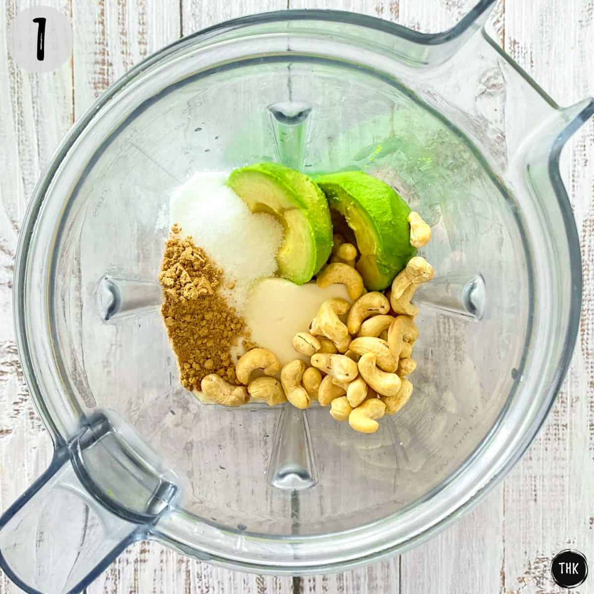 Blender with cashews, avocado, tofu, lime juice and sugar inside.
