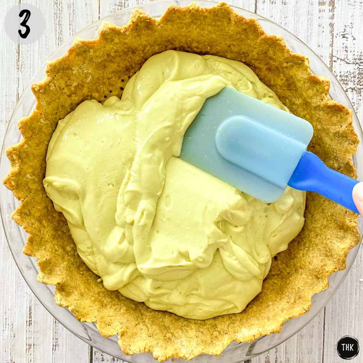 Silicone spatula spreading pie filling inside pie crust.