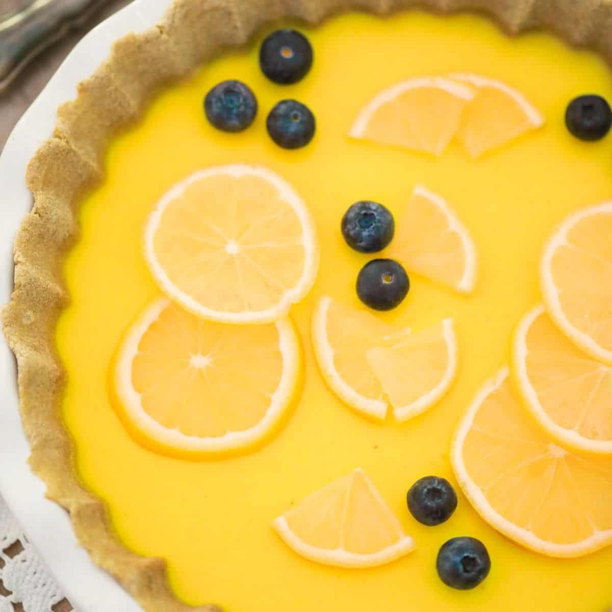 Lemon pie with lemon slices and blueberries on top.
