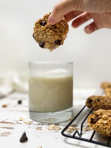 cookie being dipped into glass of milk