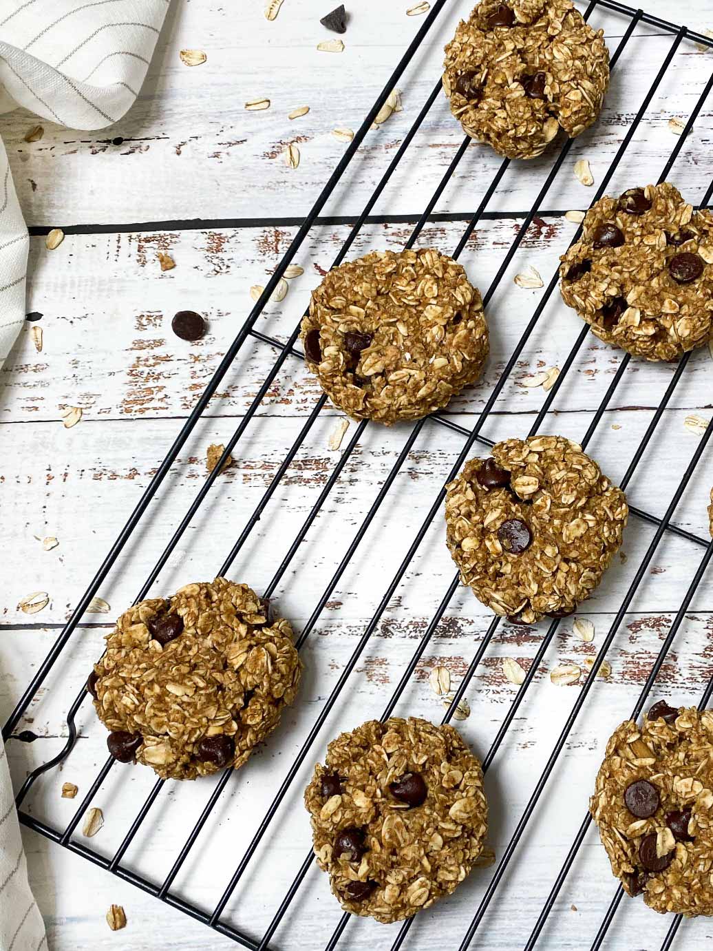 vegan oatmeal cookies with chocolate chips on cooling rack after baking