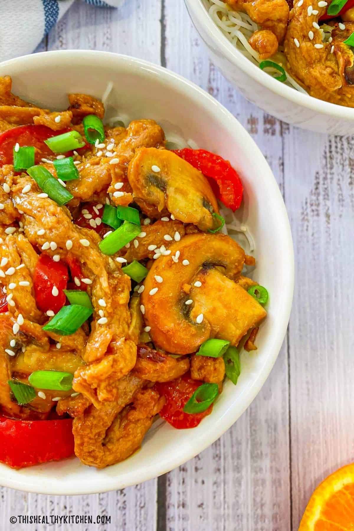 Two bowls with vegan orange chicken inside.