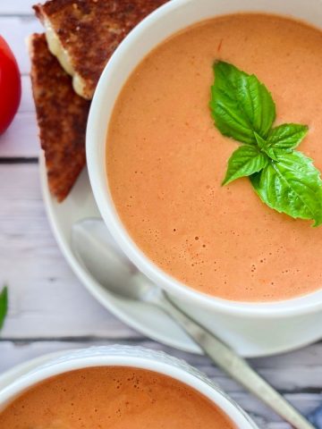 bowl of tomato soup with basil garnish on top