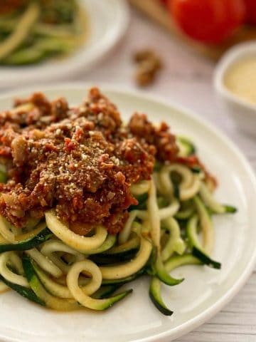plate of zucchini noodles with bolognese sauce on top.