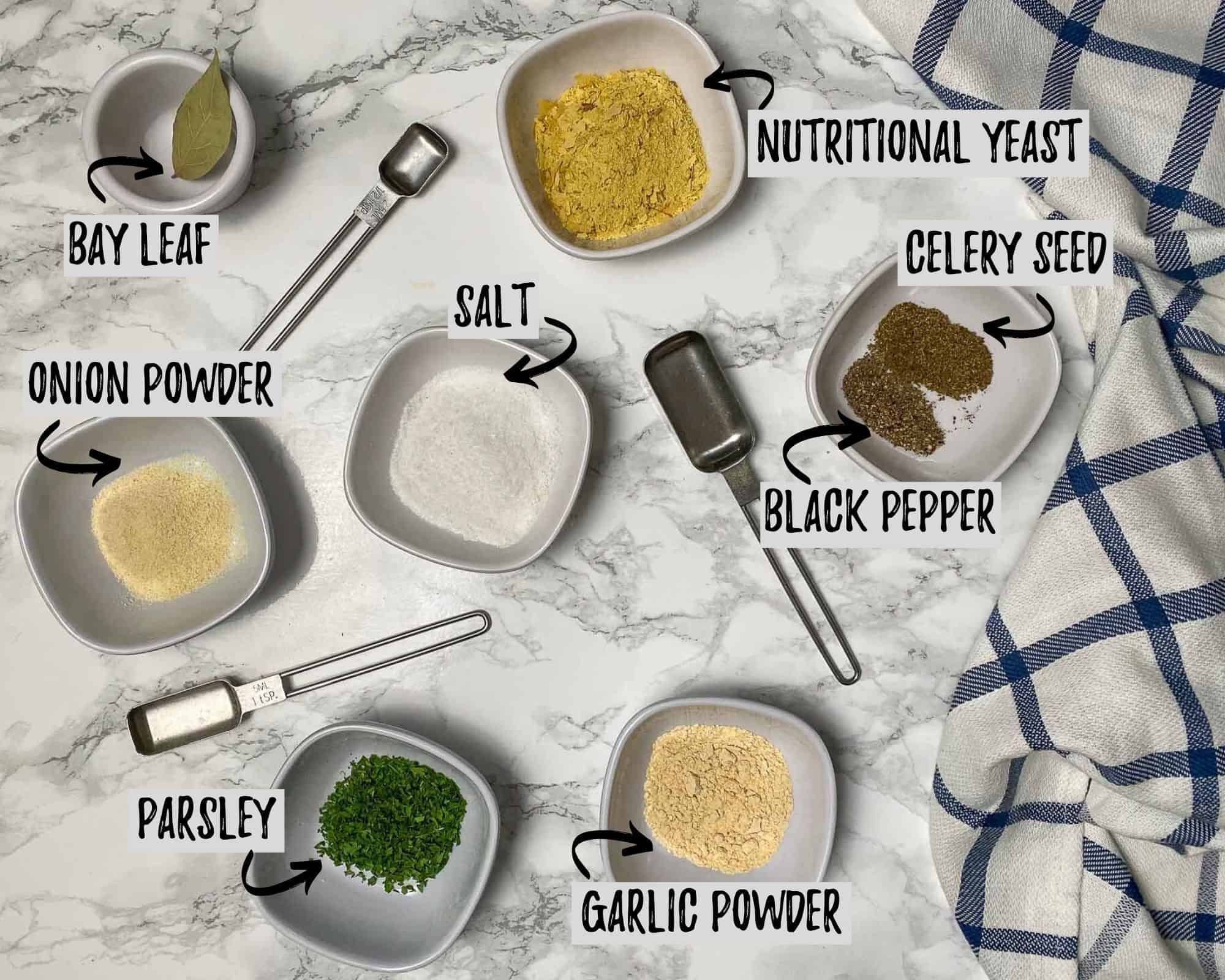 bowls of seasoning and spices scattered over marble counter top