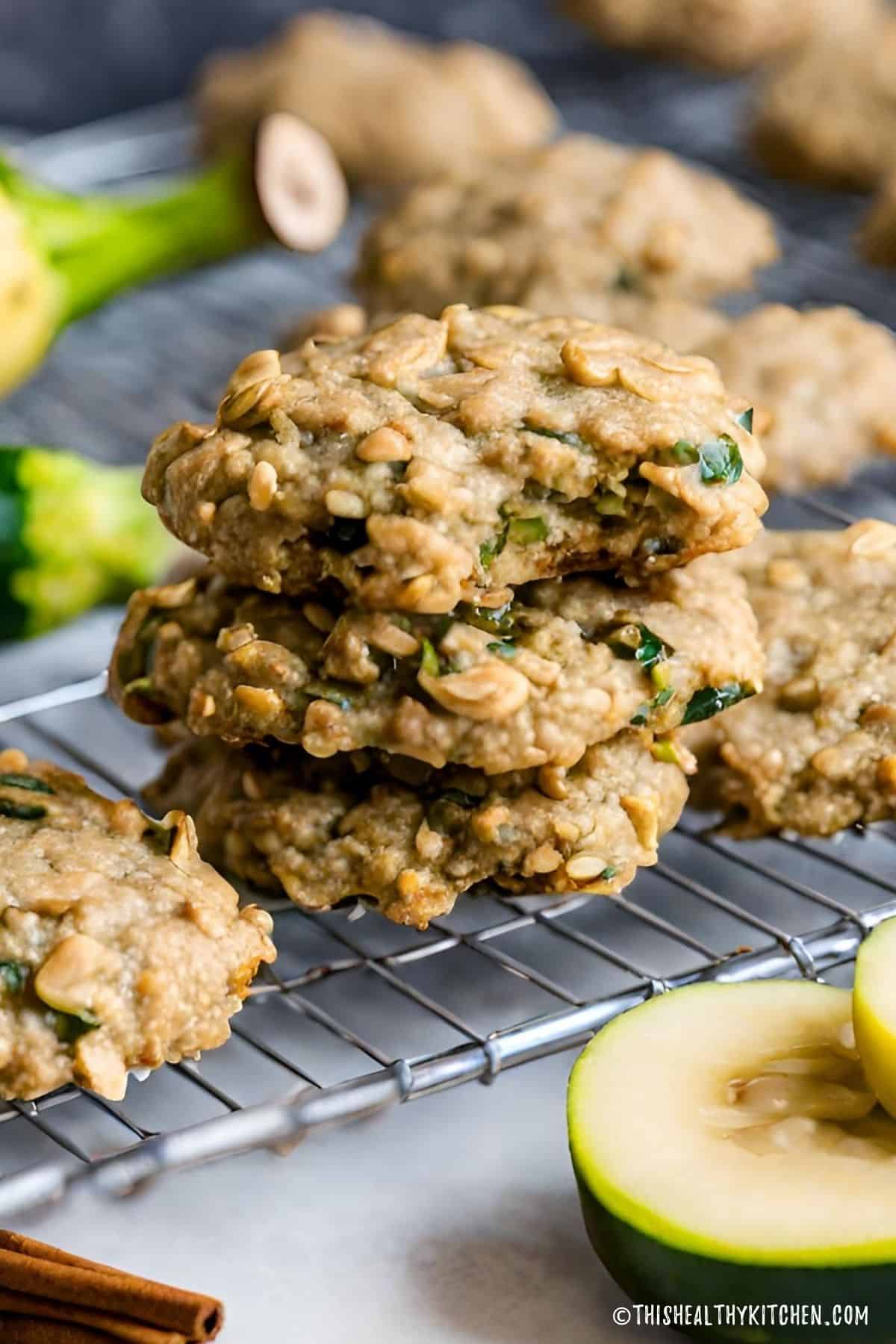 Zucchini cookies on wire rack with bite taken from one of the cookies.