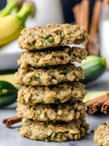 Six vegan zucchini cookies stacked on top of each other.