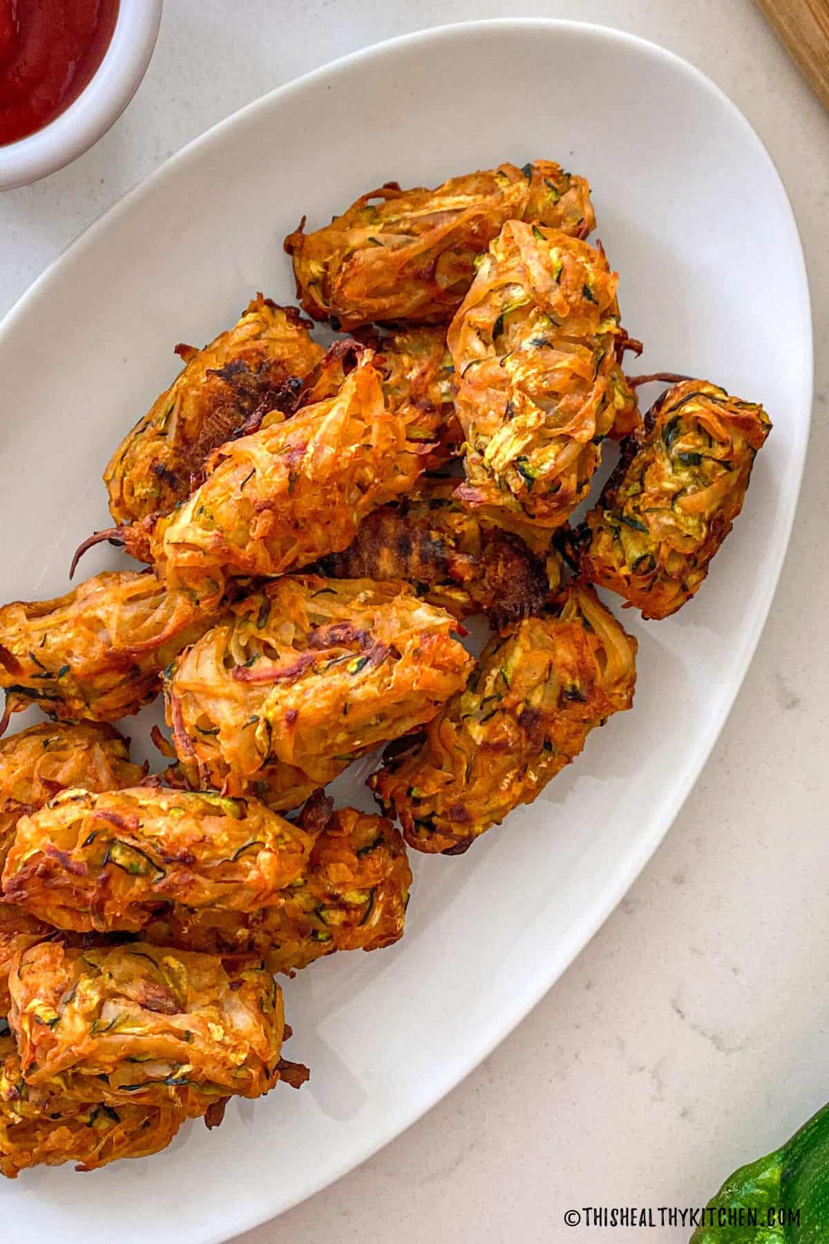Baked tater tots in white serving dish.