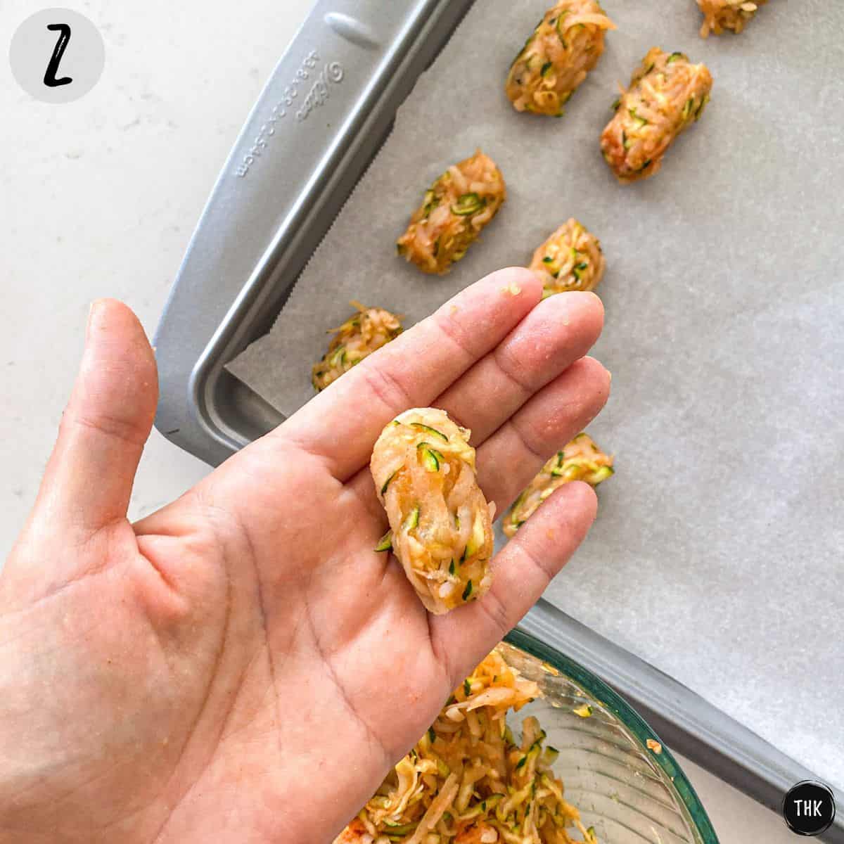 Hand holding up an unbaked tater tot.
